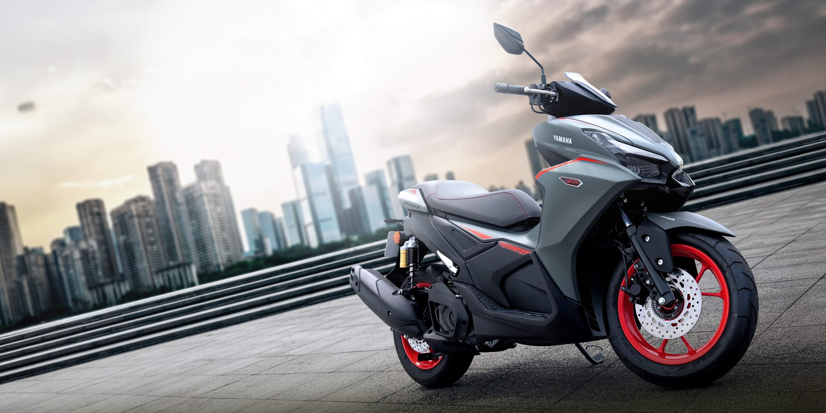都市の景色を背景にしたYAMAHA AEROX